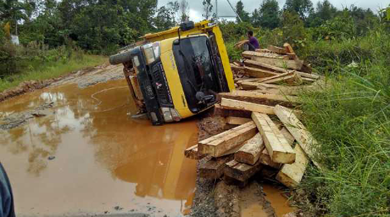 tumbang-sebuah-truk-bermuatan-kayu-yang-tumbang-saat-melintasi-lubng-yang-menganga-di-jalan-nanga-pinoh-ella