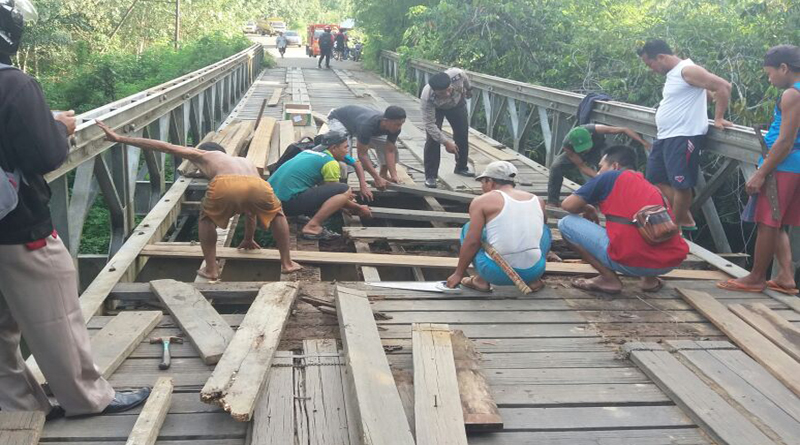swadaya-babinkamtibmas-pinoh-selatan-bersata-belasan-warga-manggala-ketika-bergotong-royong-memperbaiki-lantai-jembatan-laur-sungai-mangat-menggunakan-papan-seadanya-3