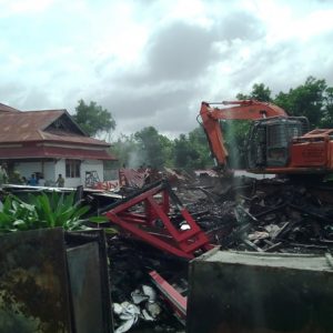 BERSIHAN. Satu unit alat berat ketika mengerok dan membersihkan puing-puing bangunan kantor Bupati Melawi yang hangus