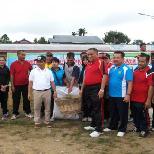 MENGANGKUT. Bupati Melawi bersama Sekda ketika mengangkat keranjang sampah dalam Pembersihan bersama lingkungan lapangan pasar kuliner---Dedi Irawan
