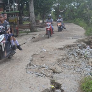 Pengendara ketika melalui Jalan M Nawawi Desa Paal yang longsornya semakin parah