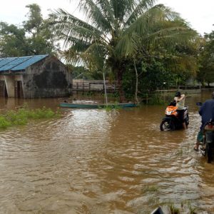 Warga ketika melalui Jalan M. Nawawi Desa paal yang terkena banjir---Dedi Irawan_2