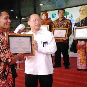 Kepala Sekolah SMPN 2 Belimbing, Budiyanto (menggunakan batik hitam merah) ketika menerima piagam penghargaan dari pihak Kementerian Lingkungan Hidup dan Kemendikbud