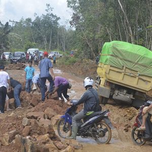 Kerusakan jalan yang semakin parah di jalur Semadin Lengkong membuat truk-truk terjebak dan menyulitkan warga melintasinya
