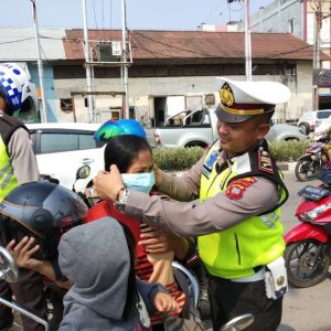 Kasat Lantas saat memasangkan masker kepada seorang Pengendara---Dedi Irawan